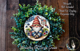 A wreath featuring a gnome wearing an American flag hat, surrounded by greenery and flowers. The gnome is holding a sign that says "Happy 250". The wreath is displayed on a wooden surface, and there is a text overlay that reads "Wreath Not Included * Used For Display Purposes Only".
