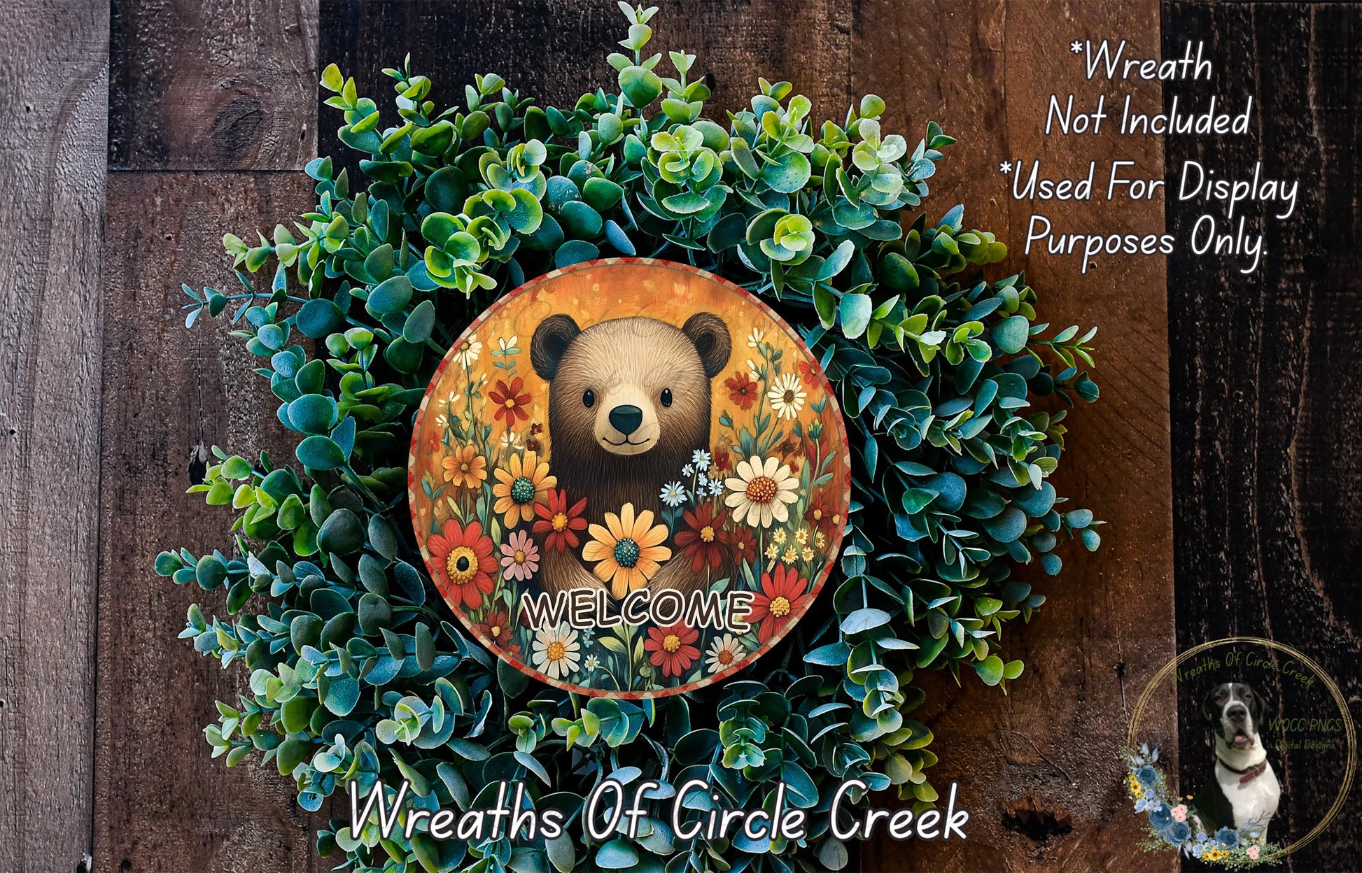 a wreath with a bear and flowers, surrounded by greenery, and a circular sign with the word "WELCOME" on it.