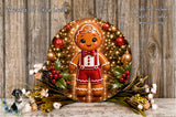 A gingerbread man figure is displayed in a wreath, surrounded by holiday decorations such as flowers and greenery, against a wooden background.