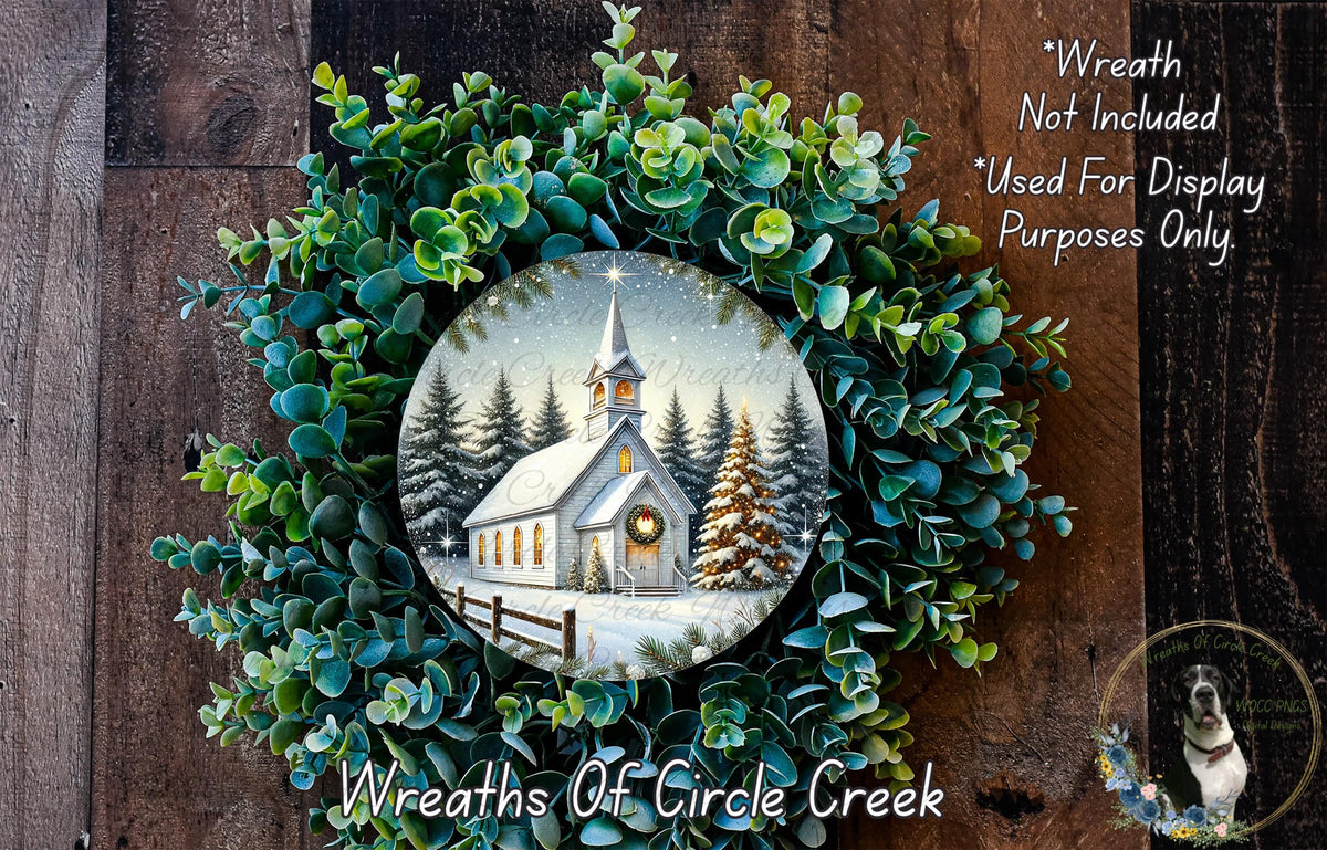A wreath with a winter scene of a church and pine trees, featuring a star in the sky, is displayed on a wooden background.