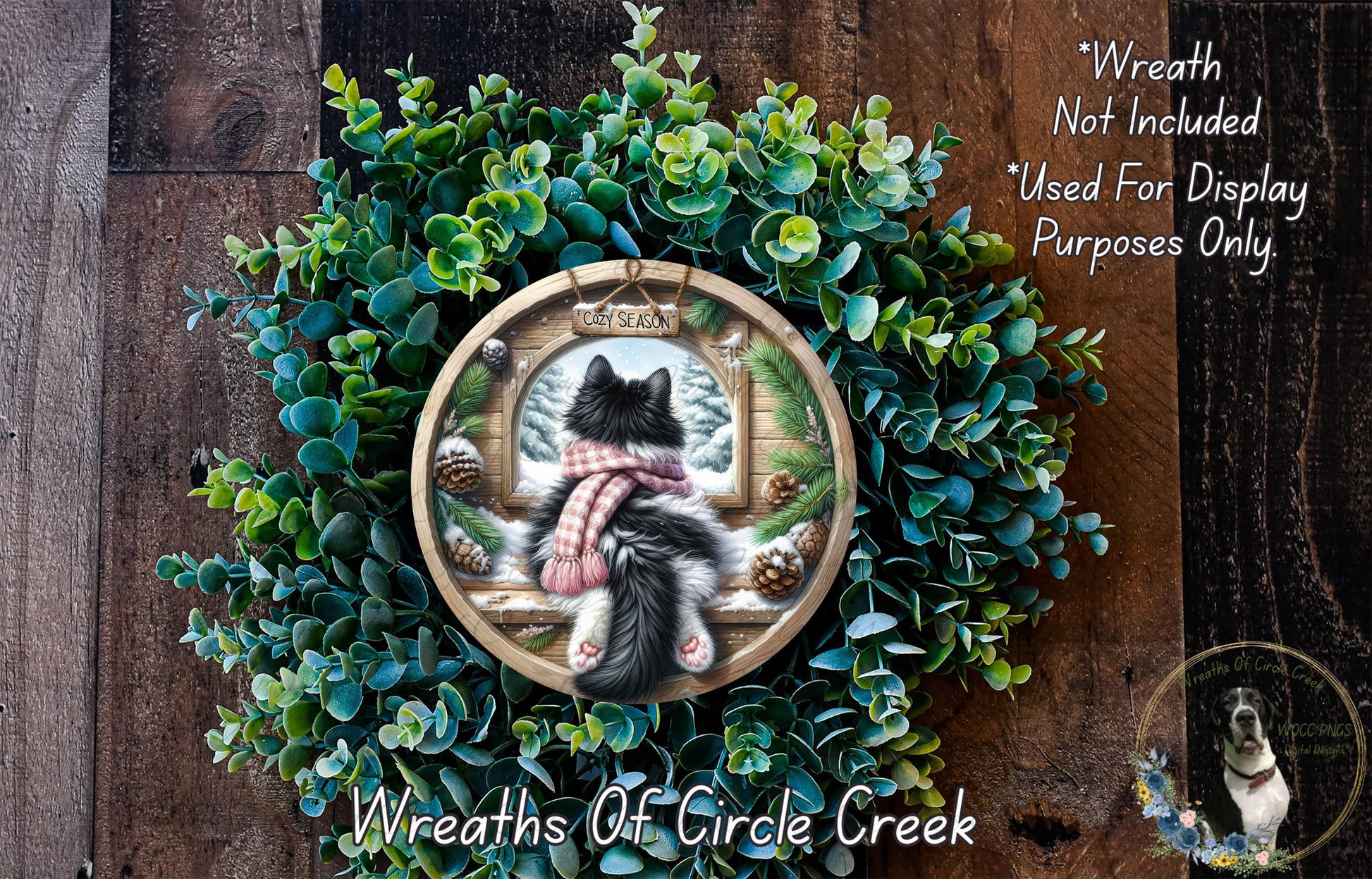A wreath with a cat sitting in a window, surrounded by greenery, and a sign that says "Wreath Not Included Used For Display Purposes Only".