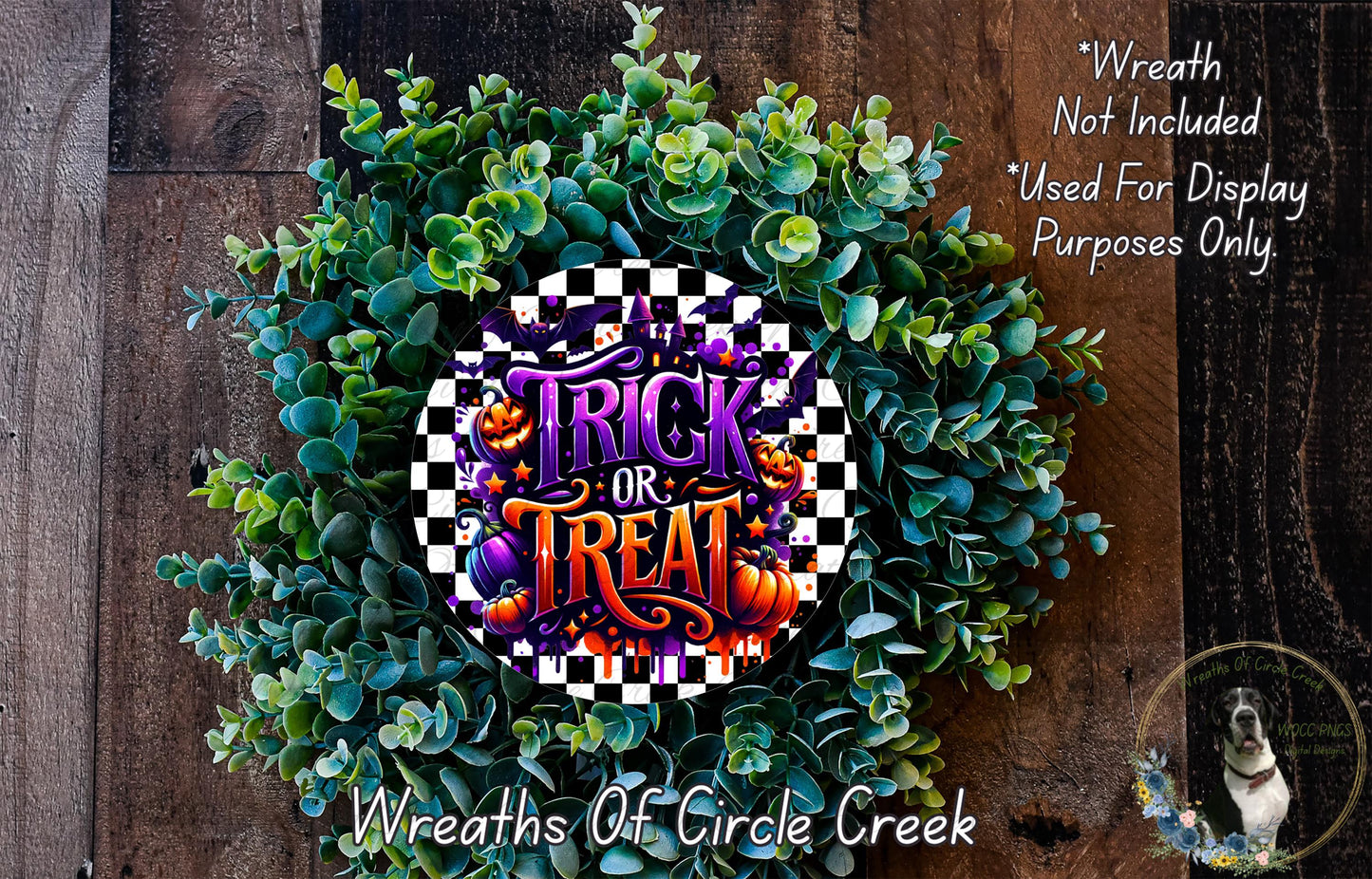 a wreath with the text "Trick or Treat" on it, surrounded by green foliage. The wreath is placed on a wooden surface, and there is a small dog in the bottom right corner of the image.
