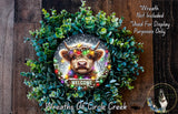 A wreath featuring a cow&#39;s head surrounded by green foliage and colorful lights, with a &quot;WELCOME&quot; sign below the cow&#39;s head.