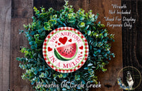 A wreath made of green leaves and a red and white sign that says "You are one in a melon".