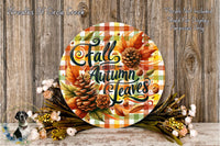 a round sign with the text "Fall Breeze and Autumn Leaves" surrounded by autumn foliage, pine cones, and flowers. The sign is placed on a wooden surface, and there are additional floral arrangements in the background.