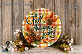 a round sign with the text "Fall Breeze and Autumn Leaves" surrounded by autumn foliage, pine cones, and flowers. The sign is placed on a wooden surface, and there are additional floral arrangements in the background.