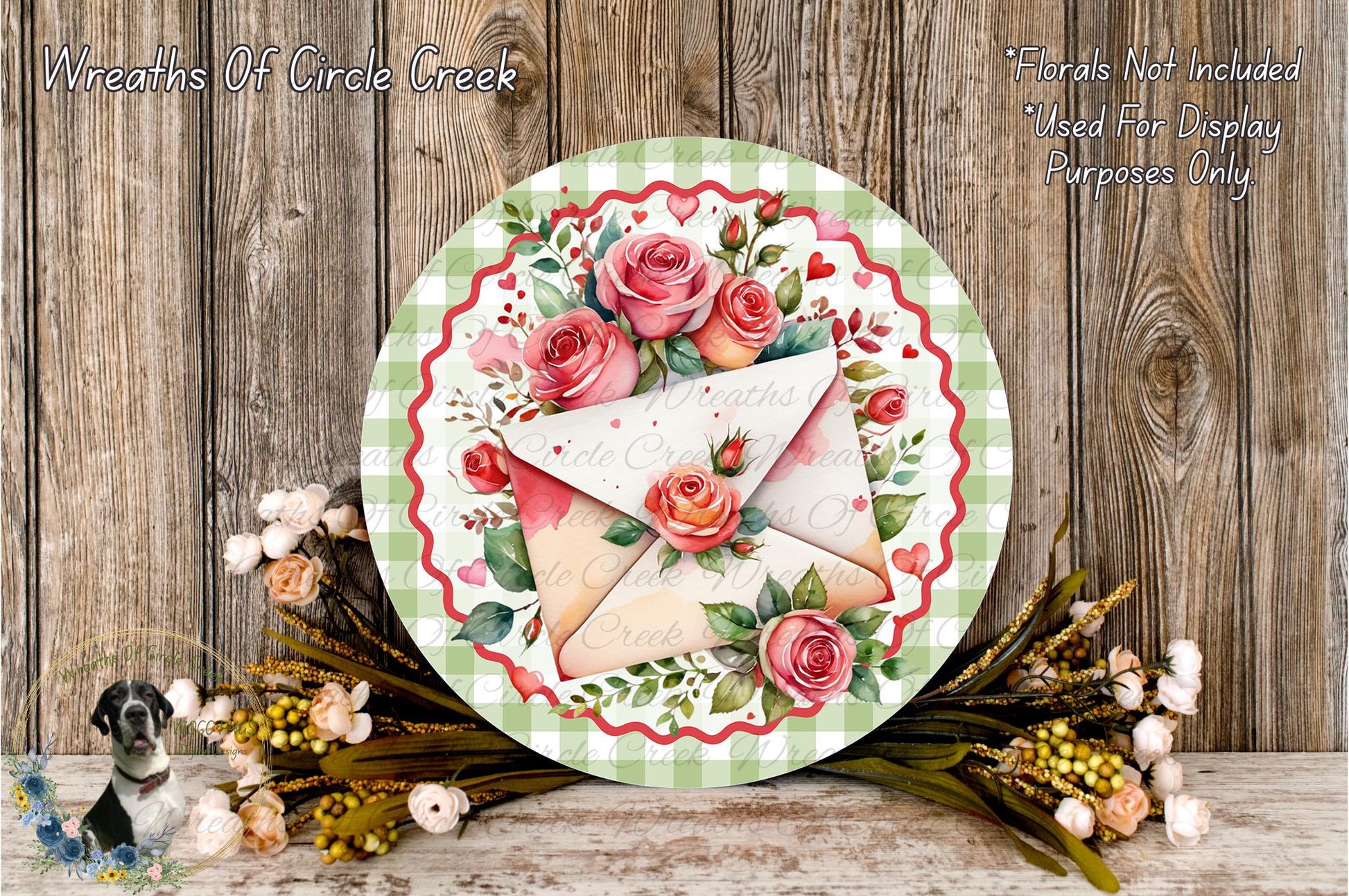a decorative wreath with a floral design, including roses and greenery, placed on a wooden surface. The wreath is surrounded by a variety of flowers and foliage, creating a visually appealing and festive display.