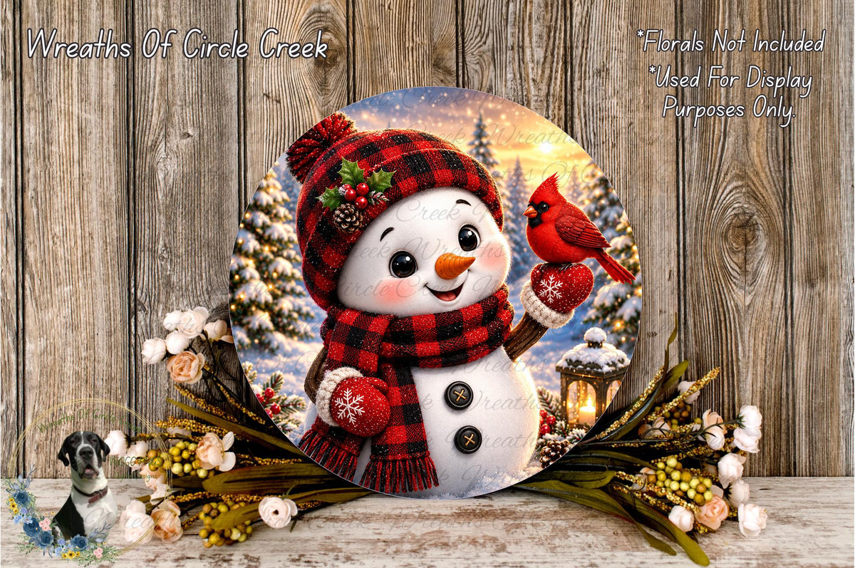 A snowman wearing a red and black plaid scarf and holding a red cardinal bird stands in front of a snowy winter landscape with trees and a lantern.