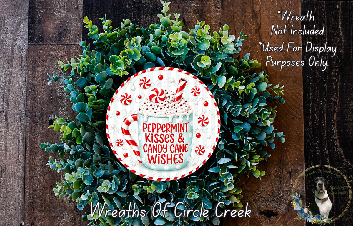 A wreath made of green leaves and a white plate with a peppermint kiss and candy cane design, placed on a wooden surface.