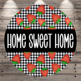 a circular design with a black and white checkered pattern and a repeating pattern of red strawberries. The text "HOME SWEET HOME" is written in white letters in the center of the design.