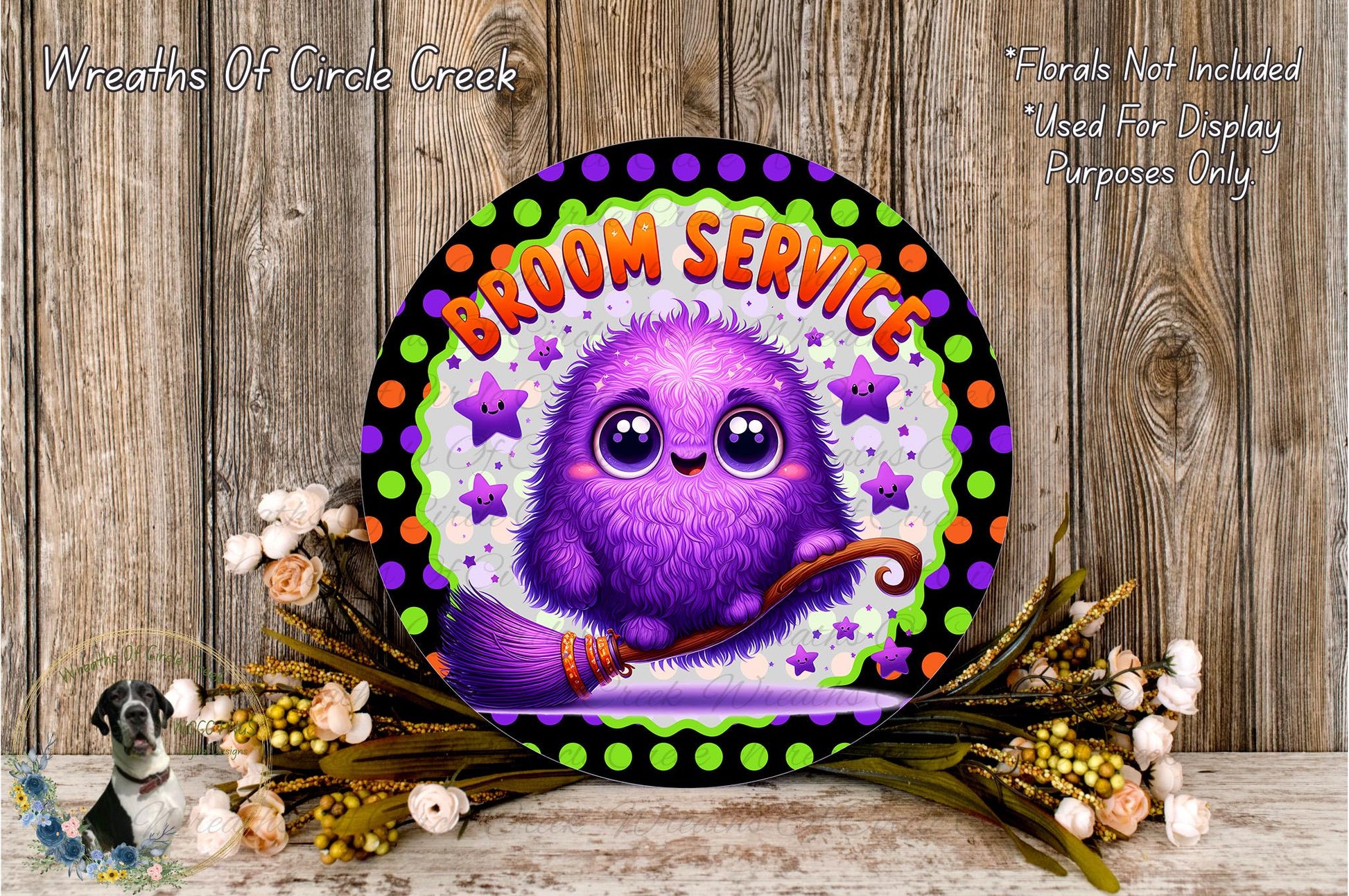 A whimsical purple broomstick character with large eyes and a friendly expression is featured on a circular sign with a floral border, surrounded by a wreath of flowers and greenery.