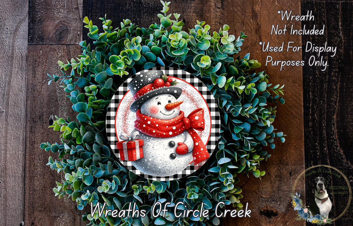 A wreath made of green foliage and featuring a snowman decoration, with a text overlay that reads "Wreath Not Included * Used For Display Purposes Only" and "Wreaths of Circle Creek".