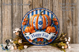 A decorative wreath with a blue and white striped border, featuring a large orange pumpkin surrounded by smaller pumpkins and flowers. The wreath is placed on a wooden surface, and there is a banner that reads &quot;Happy Fall&quot;.