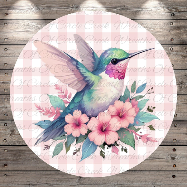 A colorful hummingbird is depicted in flight, surrounded by pink flowers and green leaves against a pink and white checkered background.