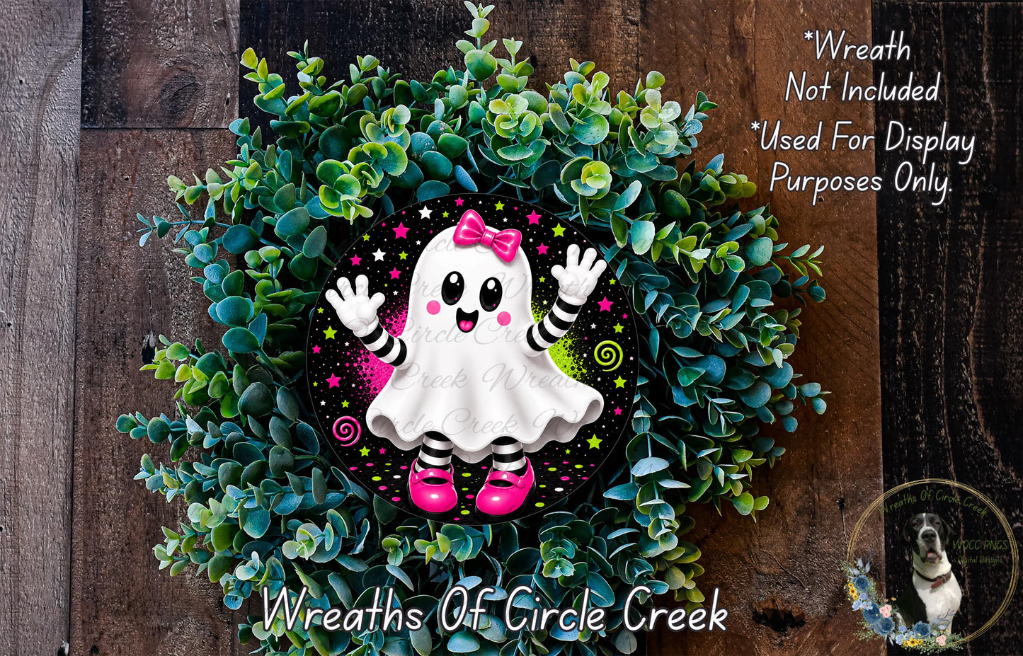 A wreath made of green foliage and featuring a ghost character with pink shoes and a bow, placed on a wooden surface.