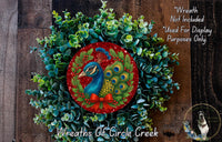 A wreath made of green leaves and red berries, with a large red circle in the center featuring a blue peacock with a red bow.