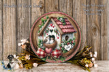 a decorative wreath with a birdhouse, flowers, and a bow, placed on a wooden surface.