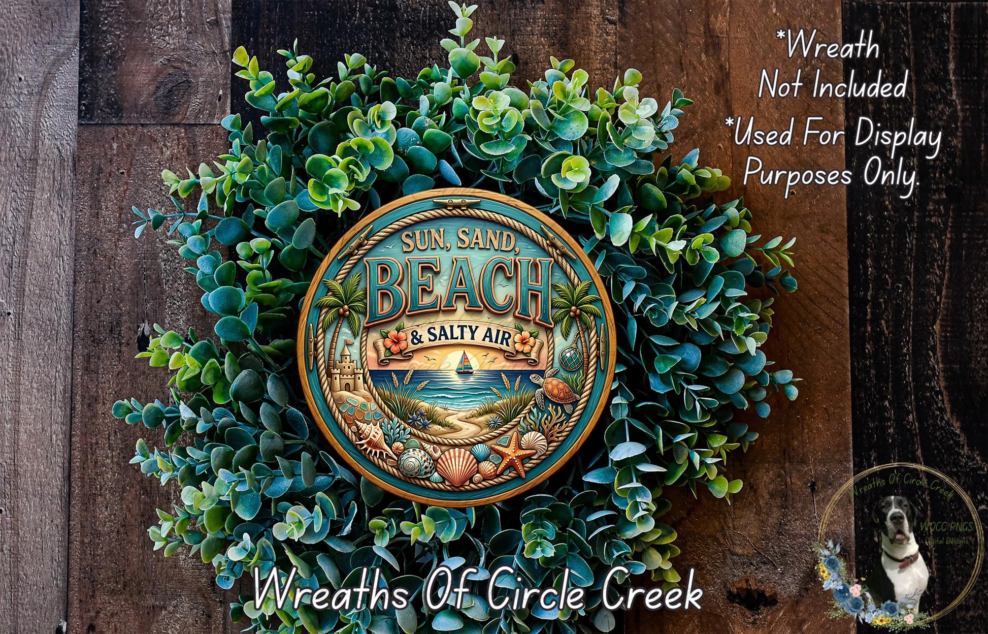 a wreath made of various green plants and a circular sign with the text "Sun, Sand, Beach & Salty Air" on it, placed on a wooden surface.