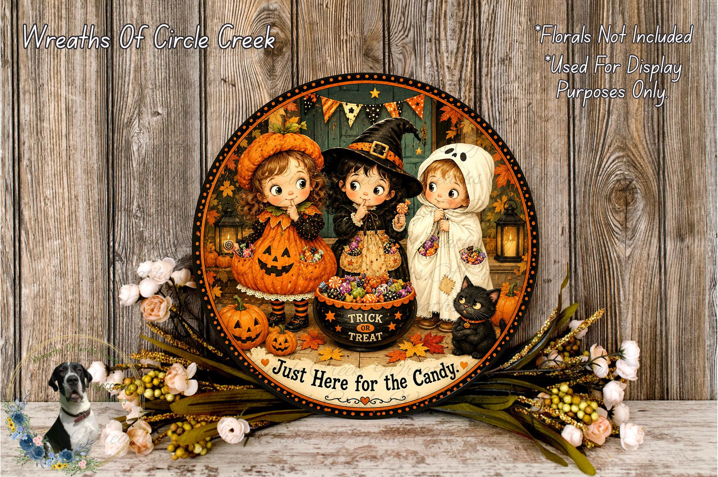 A Halloween-themed plate featuring three cartoon children dressed in costumes, with a black cat and pumpkins, surrounded by a floral arrangement and the text "Just Here for the Candy".