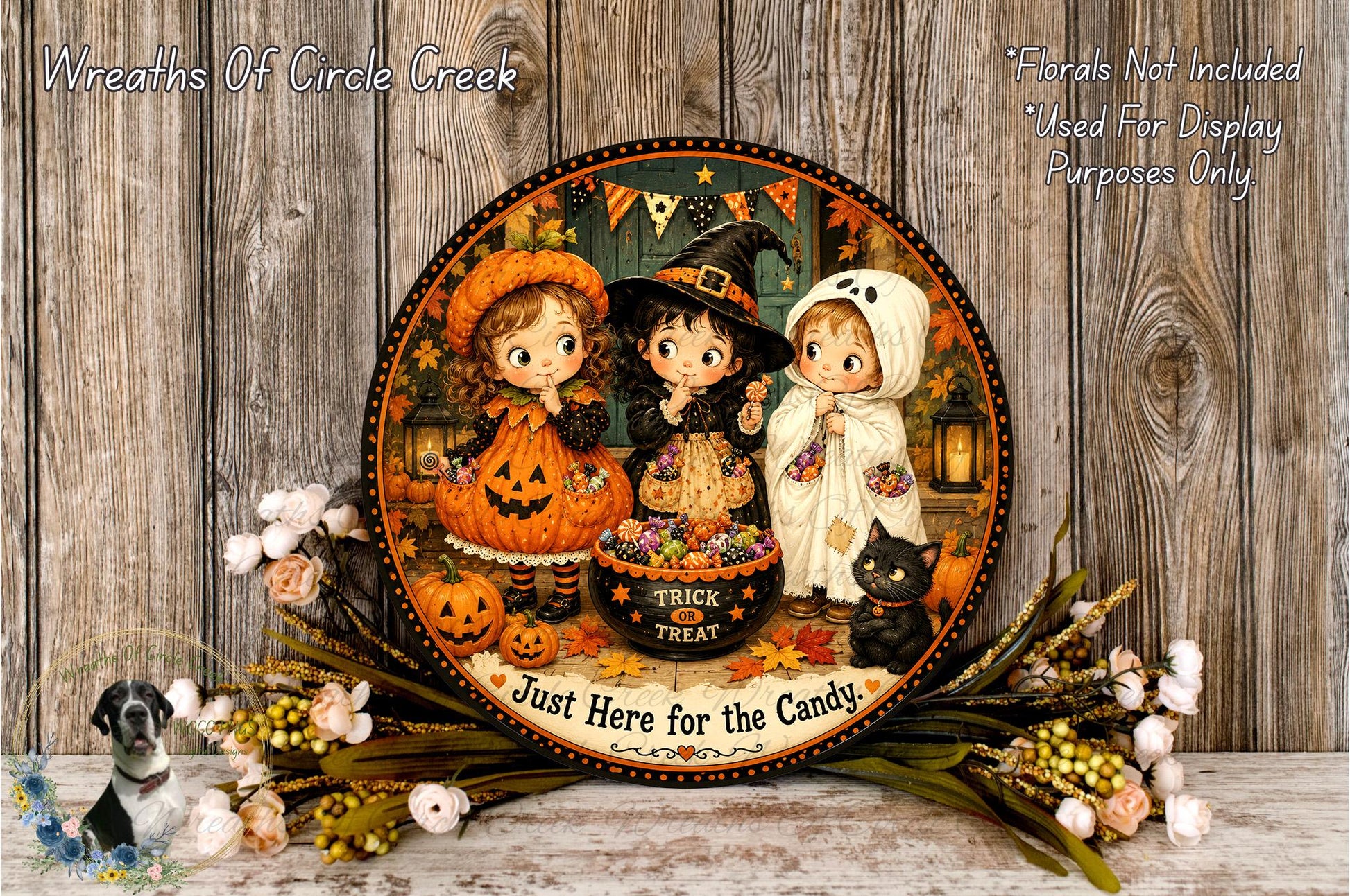 A Halloween-themed plate featuring three cartoon children dressed in costumes, with a black cat and pumpkins, surrounded by a floral arrangement and the text "Just Here for the Candy".