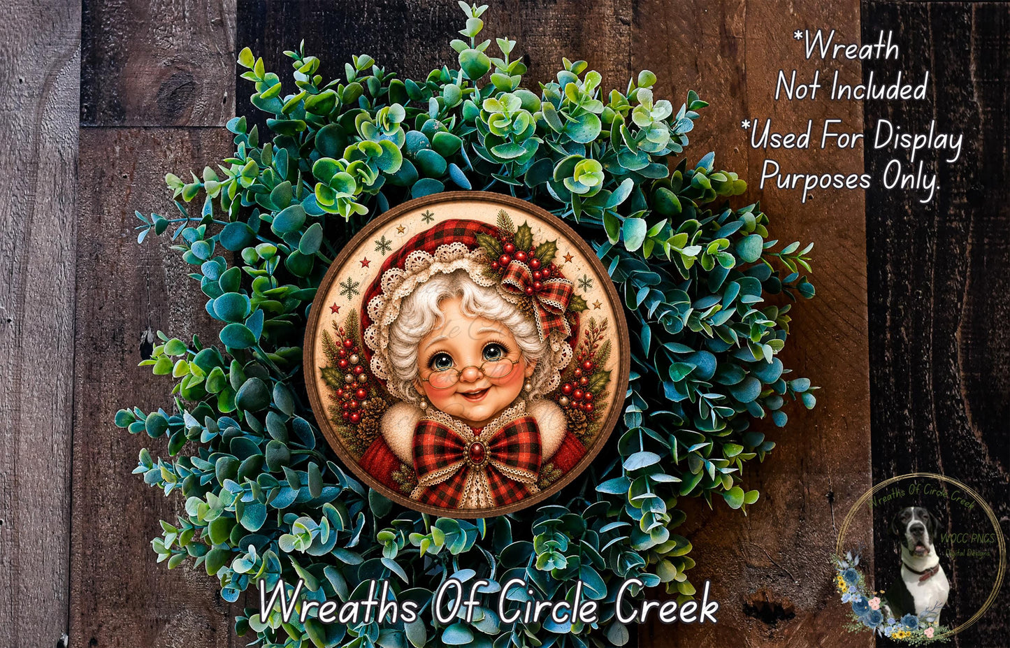 A wreath featuring a portrait of a smiling elderly woman, surrounded by green foliage.