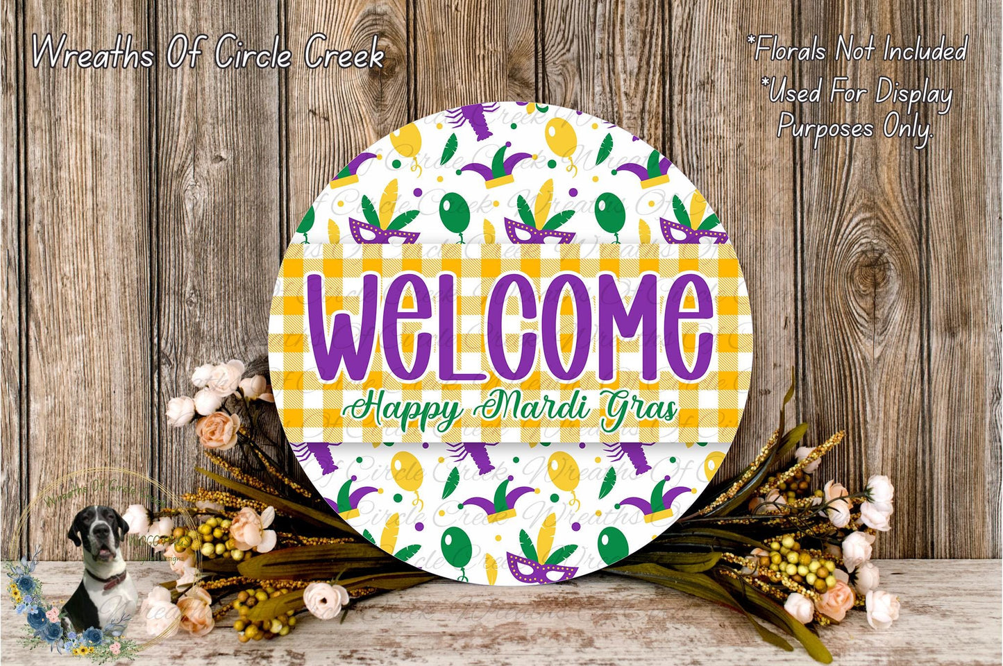 a circular sign with the text "Welcome Happy Mardi Gras" displayed on it, surrounded by a floral arrangement and a wooden background.