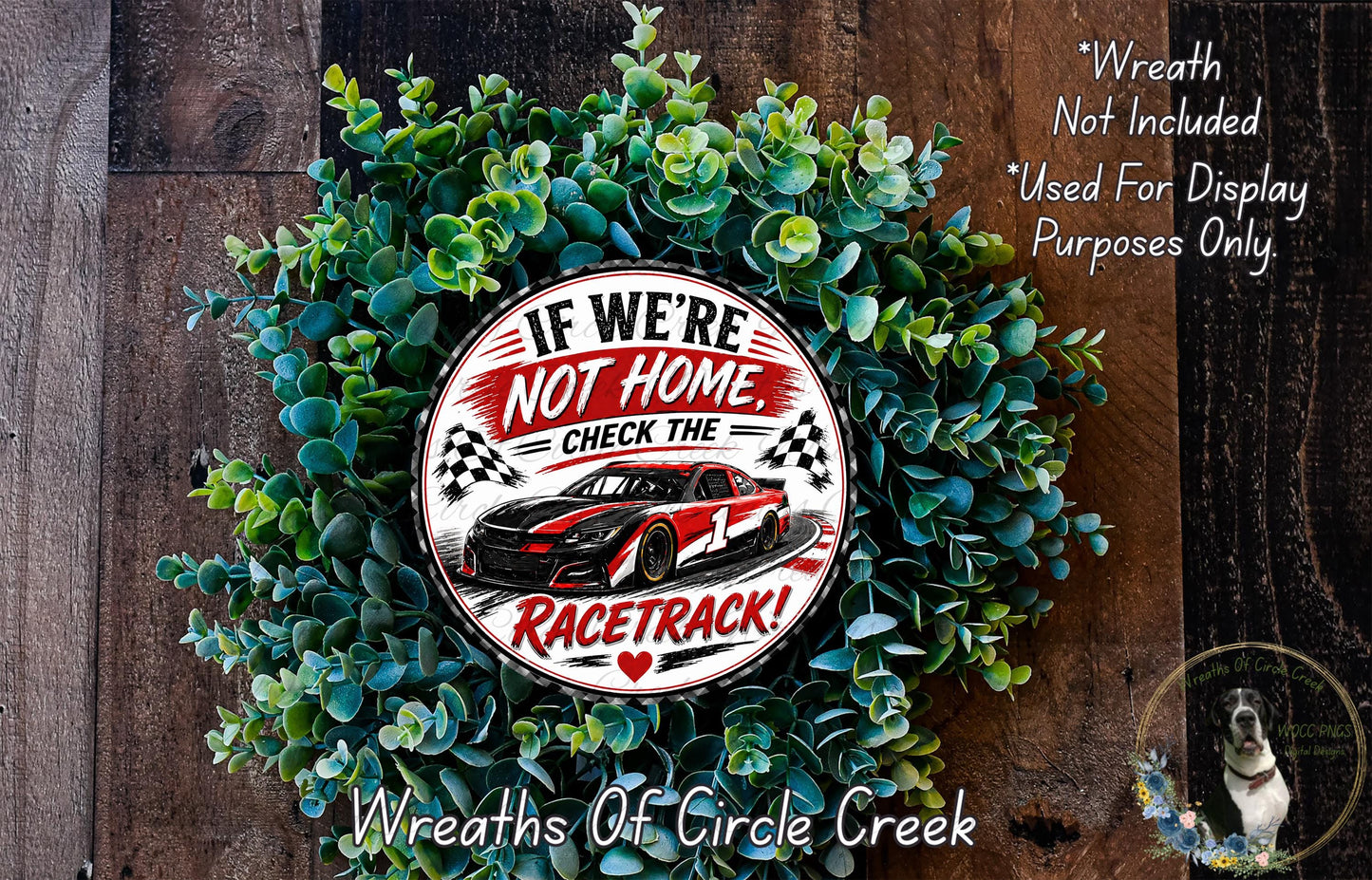 a wreath made of green leaves and a red and white sign with a racing car design, placed on a wooden surface.