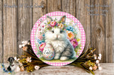 A decorative Easter-themed plate featuring a white and gray rabbit wearing a flower crown, surrounded by a floral arrangement and a basket of Easter eggs.