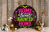 A decorative sign with the text "HOME SWEET HAUNTED HOME" in a circular design, surrounded by a floral arrangement and a wooden background.