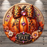 A decorative wreath with a leopard print bow, surrounded by autumn leaves, flowers, and a sign that says "Welcome Fall".