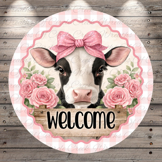 A cow wearing a pink bow and surrounded by pink roses, with the word "Welcome" written below.