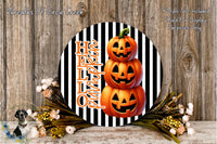 a Halloween-themed decoration with a black and white striped background, a circular arrangement of three jack-o'-lanterns, and a floral arrangement on the side.