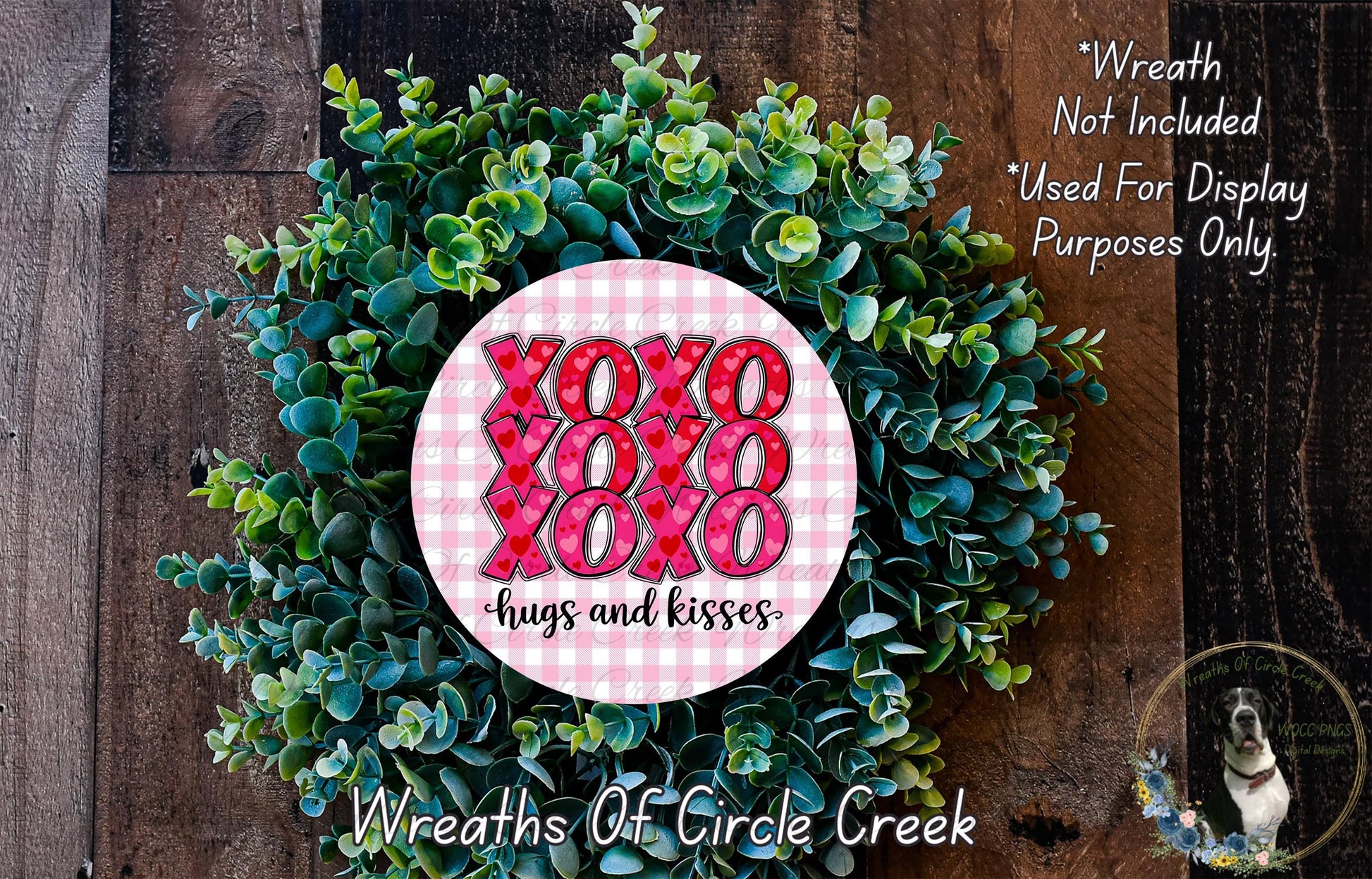 a wreath made of green leaves and a pink circular sign with the text "XOXO hugs and kisses" in the center.