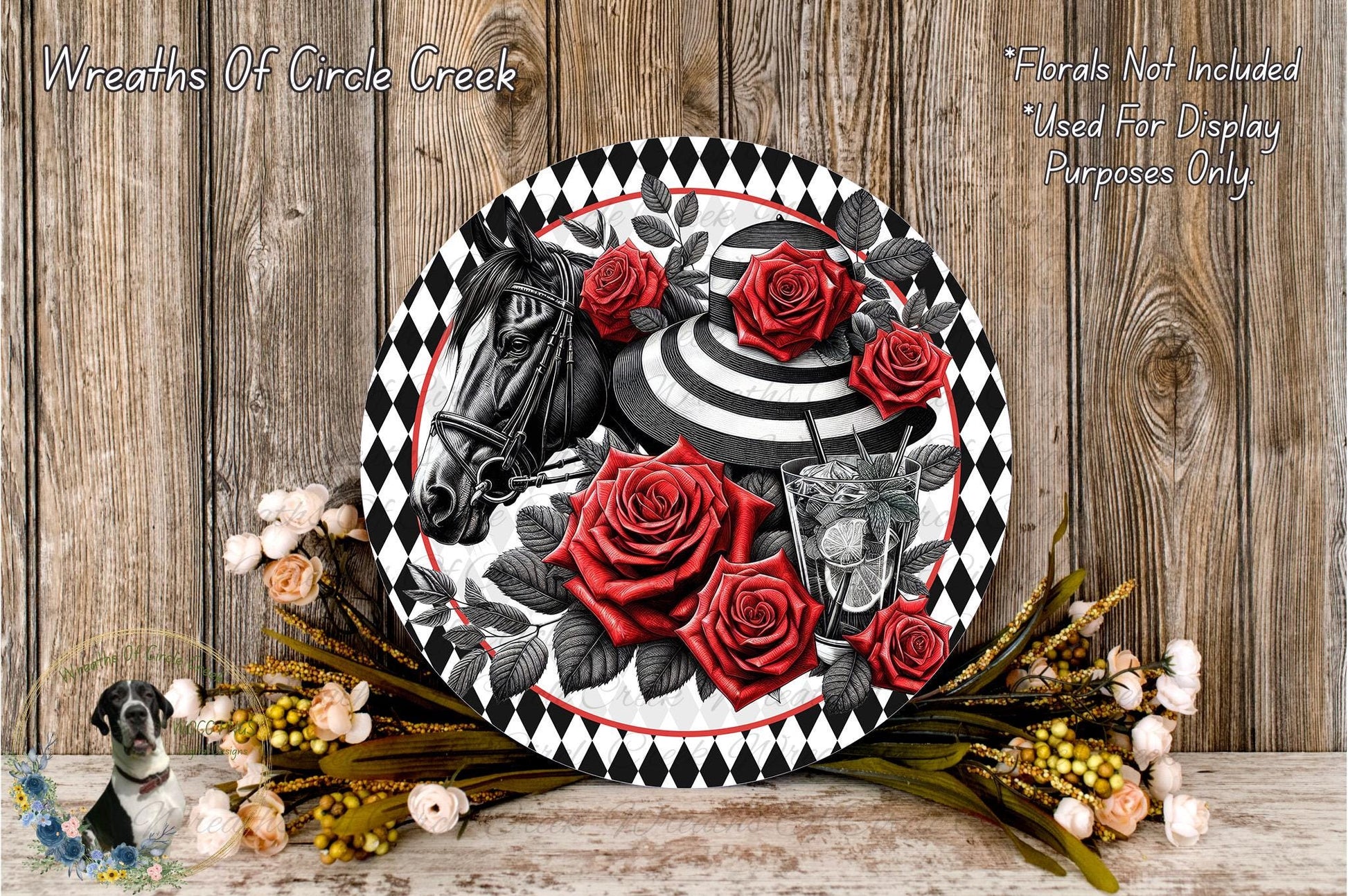 a decorative plate with a black and white design, surrounded by red roses and greenery. The plate is placed on a wooden surface, and there are additional flowers and greenery nearby.