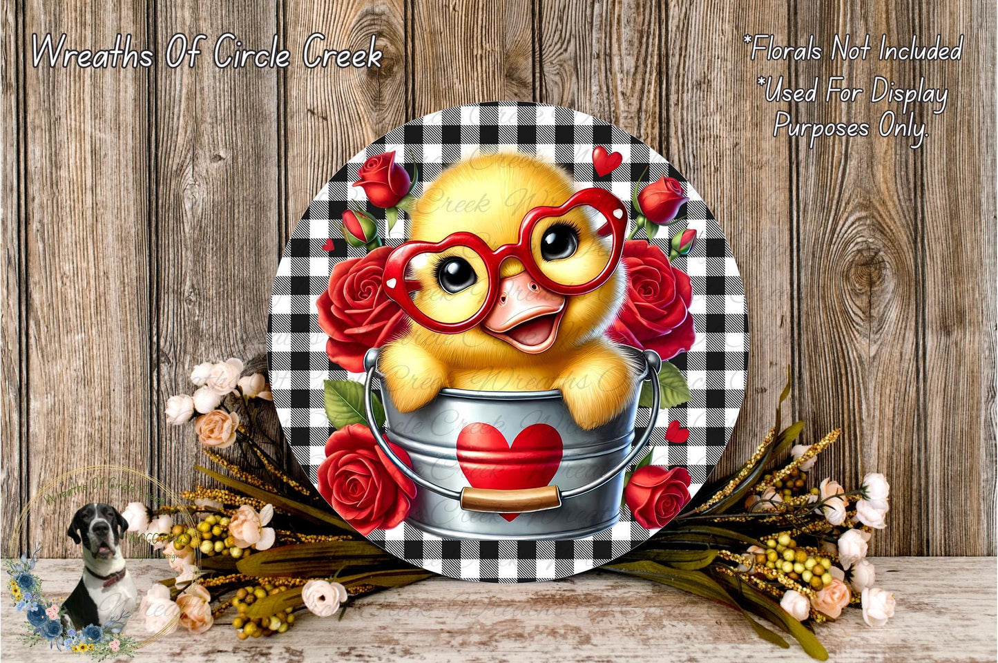 A cheerful yellow duck wearing red glasses and a red heart on a bucket, surrounded by red roses and a black and white checkered background.
