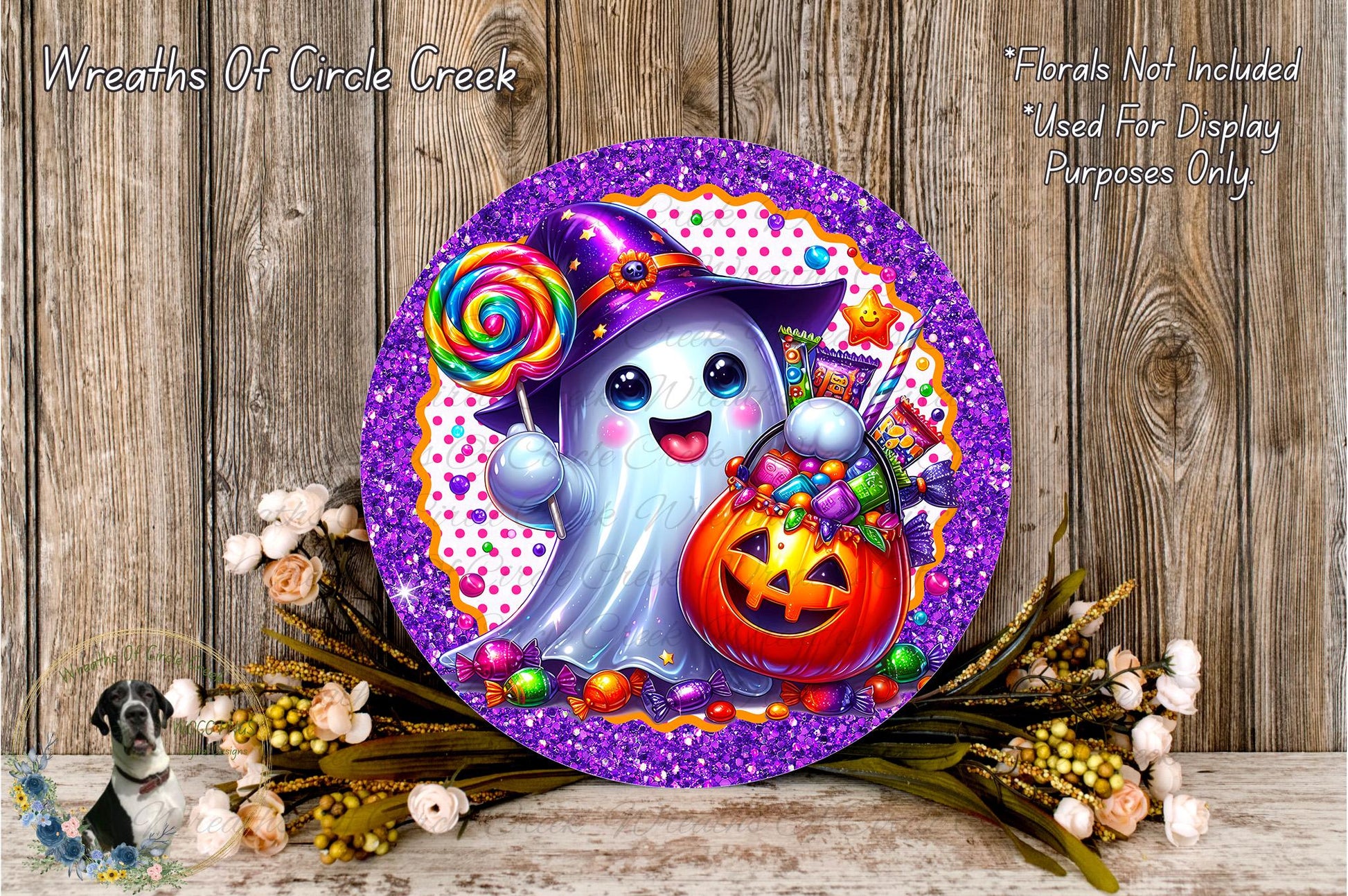 a whimsical Halloween-themed decoration with a purple and gold glittery frame, a ghost character holding a lollipop and a carved pumpkin, surrounded by flowers and greenery.