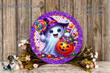 a whimsical Halloween-themed decoration with a purple and gold glittery frame, a ghost character holding a lollipop and a carved pumpkin, surrounded by flowers and greenery.