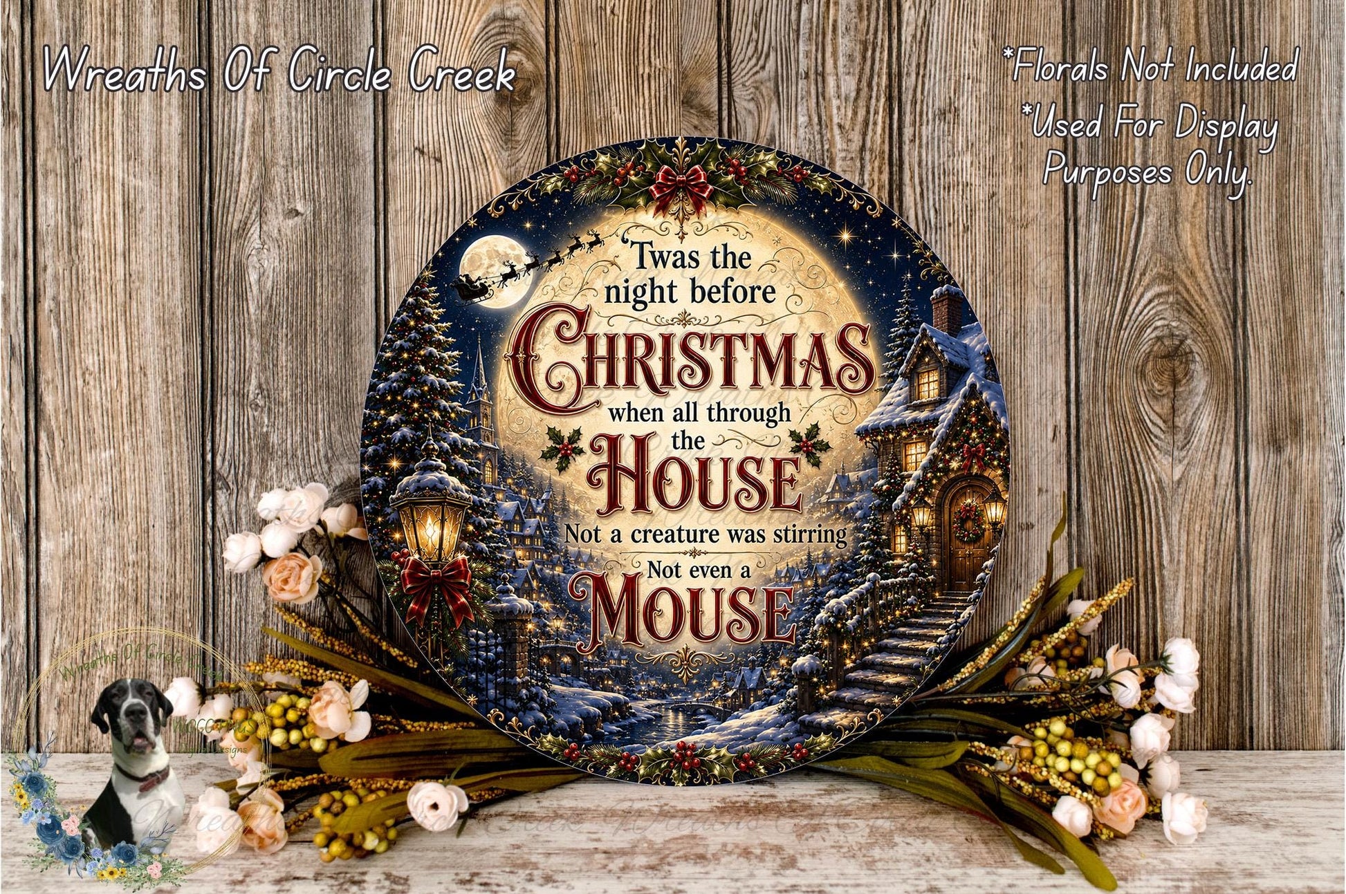 a decorative Christmas wreath with a whimsical scene of a mouse and a house, surrounded by flowers and greenery.
