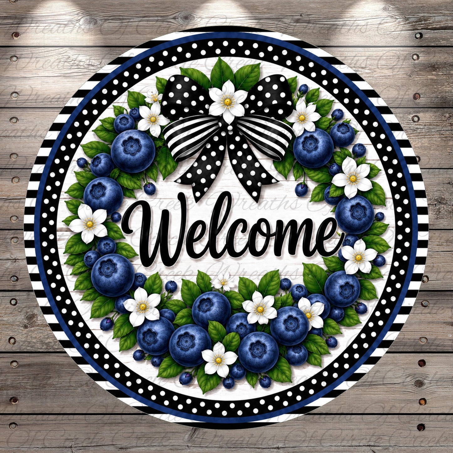 A decorative wreath with a black and white polka dot border, featuring blueberries, white flowers, and green leaves. The word "Welcome" is prominently displayed in the center of the wreath.