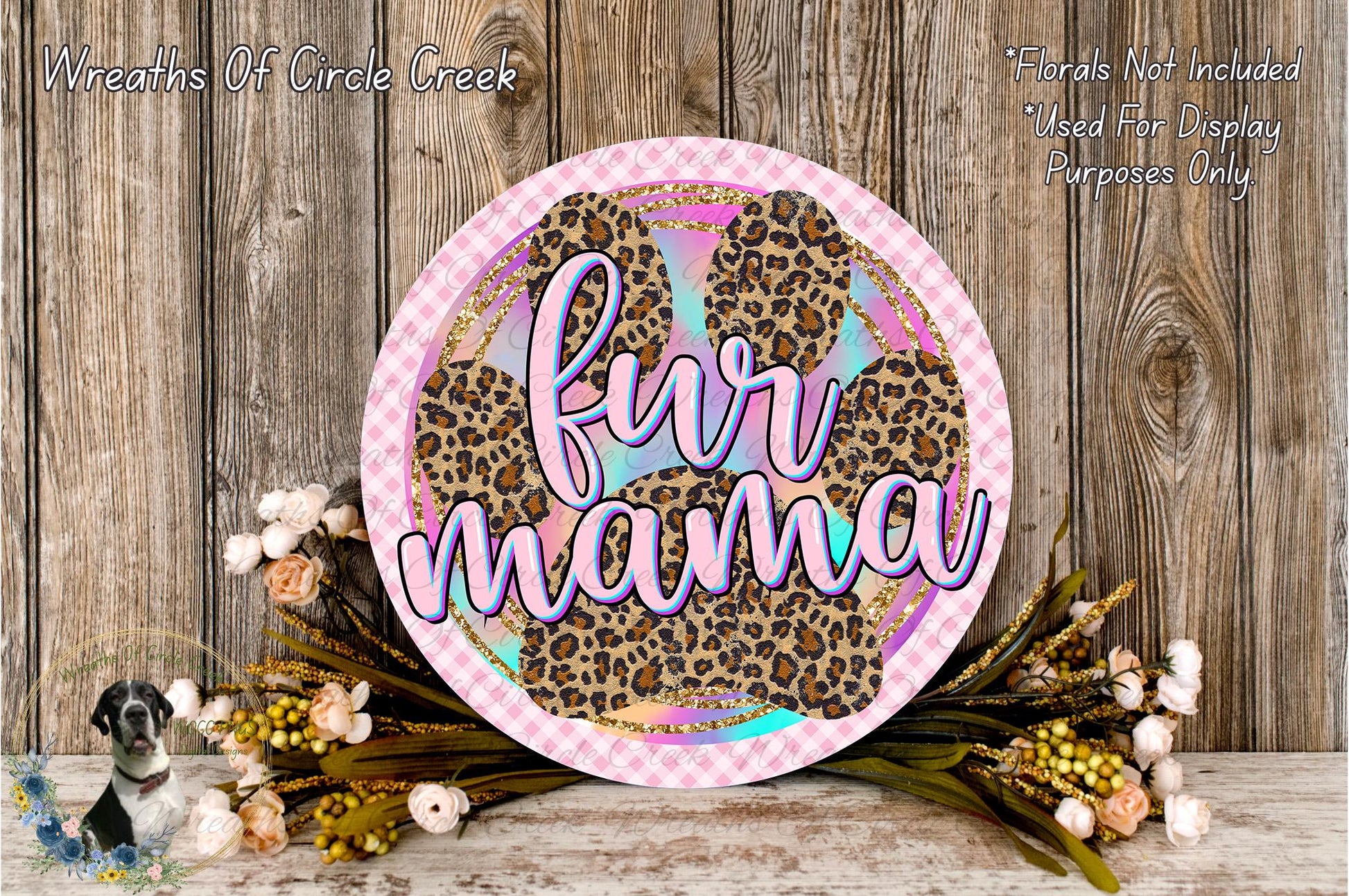 a decorative sign with the text "fur mama" in a stylized font, surrounded by a floral arrangement and a wooden background.