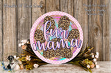a decorative sign with the text "fur mama" in a stylized font, surrounded by a floral arrangement and a wooden background.