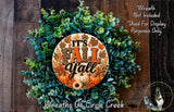 a wreath made of various fall-themed elements, including pine cones, pumpkins, and leaves, with the text "It's Fall Y'all" prominently displayed on the wreath.