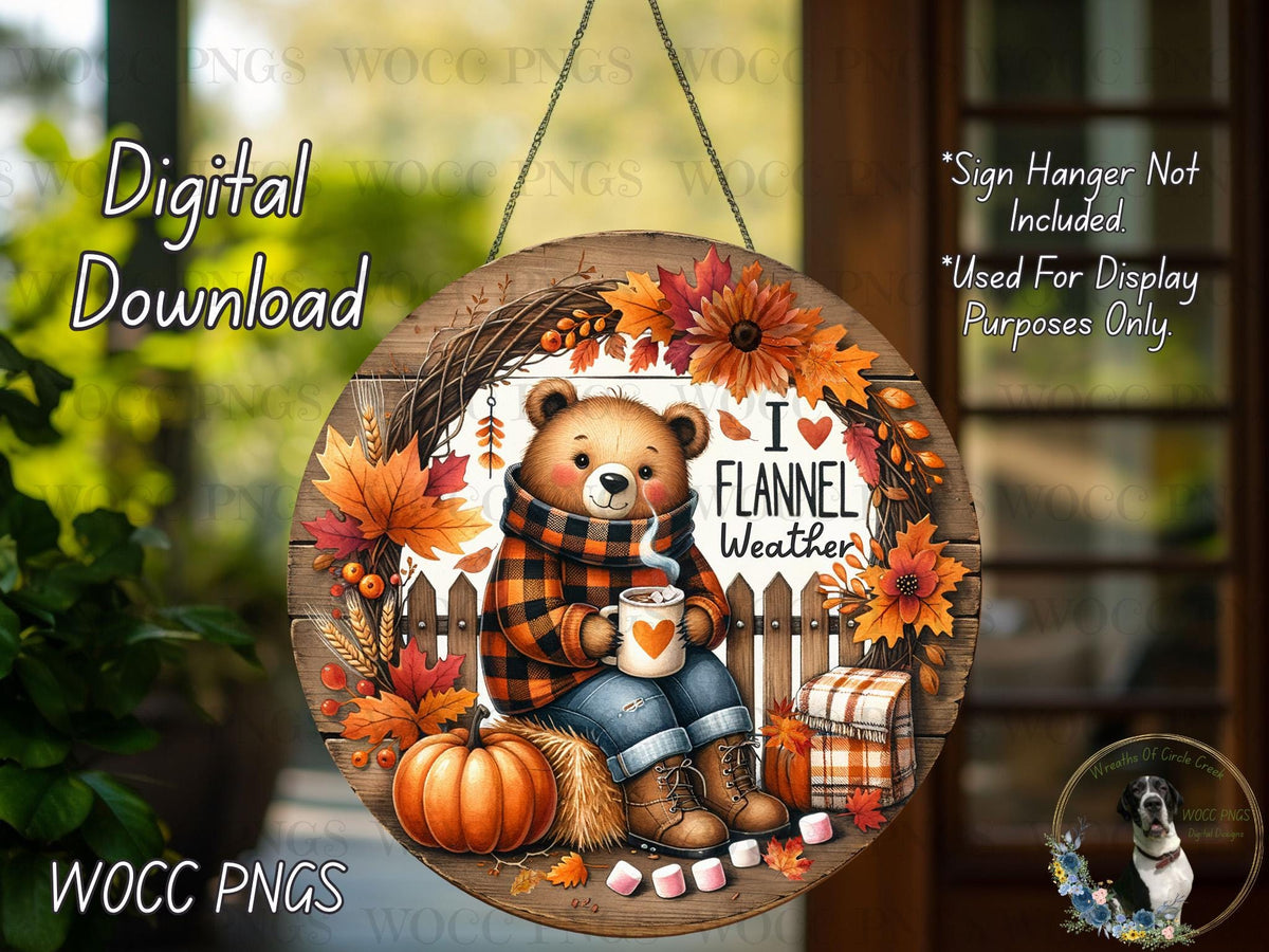 The image is a digital download of a round wooden sign featuring a bear wearing a plaid scarf and holding a mug, surrounded by autumn decorations such as leaves, pumpkins, and flowers.