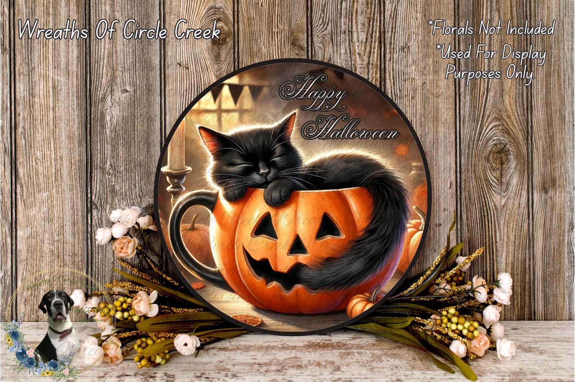 A Halloween-themed wreath featuring a black cat sleeping in a carved pumpkin, surrounded by flowers and a wooden background.