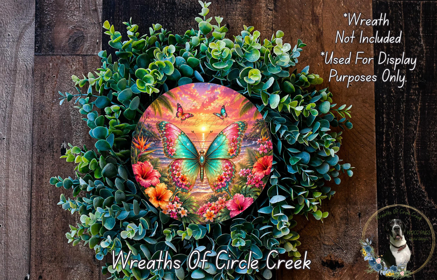A wreath made of green leaves and flowers, with a colorful butterfly design in the center. The wreath is displayed on a wooden surface, and there is a small dog in the bottom right corner.
