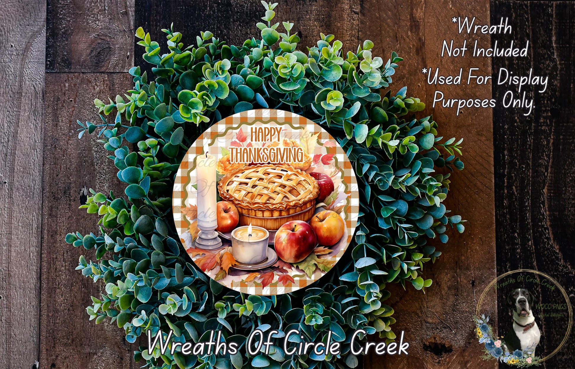 A wreath made of green leaves and featuring a pie, apples, and a candle, with the text "Happy Thanksgiving" displayed on it.