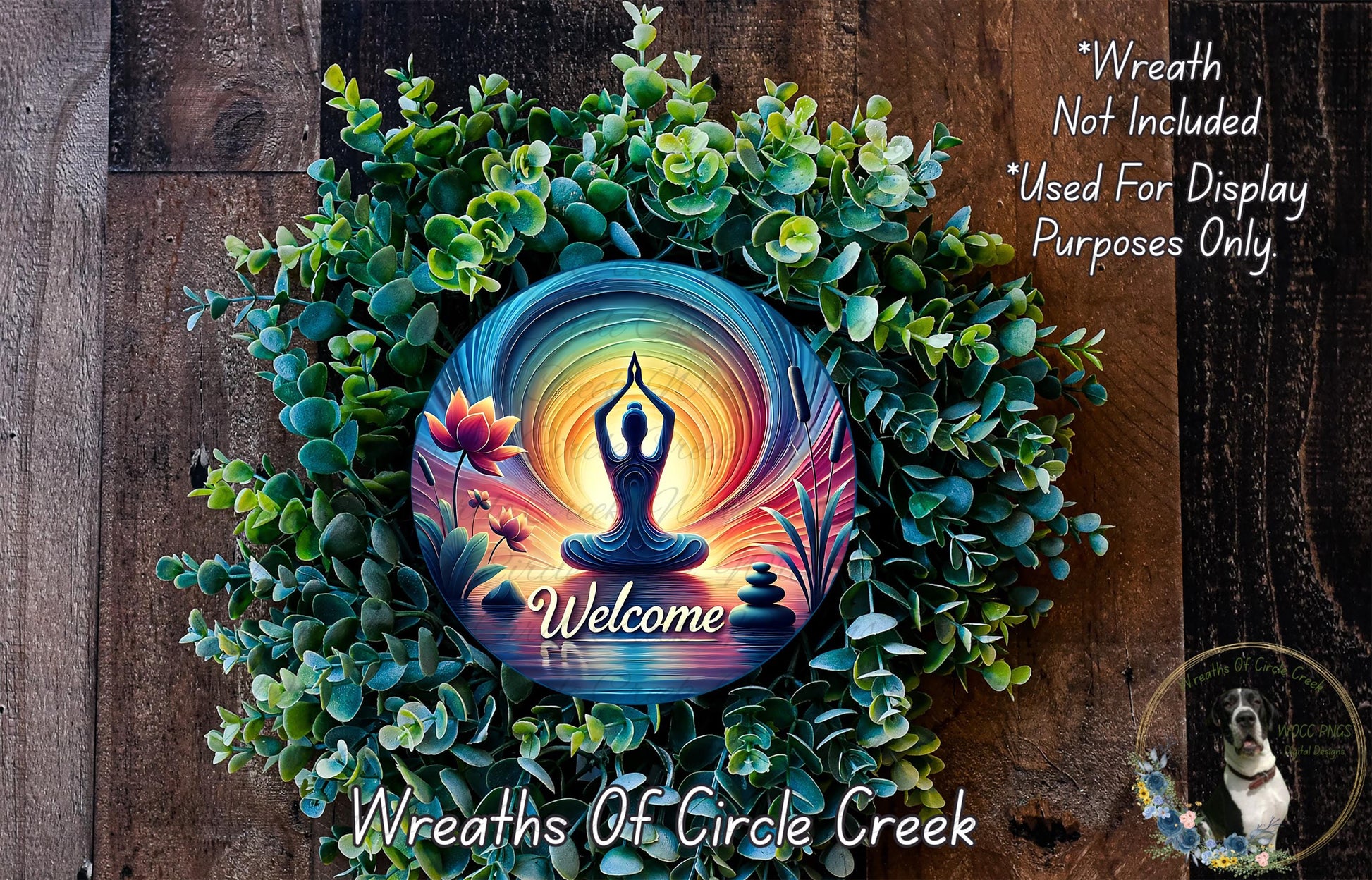 a wreath with a colorful design, including a Buddha symbol, surrounded by greenery and flowers. The wreath is placed on a wooden surface, and there is a text overlay that reads "Welcome Wreath Not Included * Used For Display Purposes Only".