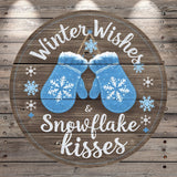 A circular wooden sign with a winter theme, featuring a pair of blue mittens and snowflakes. The sign has the text "Winter Wishes & Snowflake Kisses" written on it.