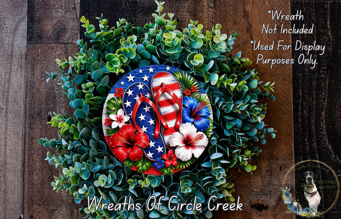 a wreath made of various greenery and flowers, including red and white flowers, and a pair of flip-flops. The wreath is displayed on a wooden surface, and there is a small dog in the background.
