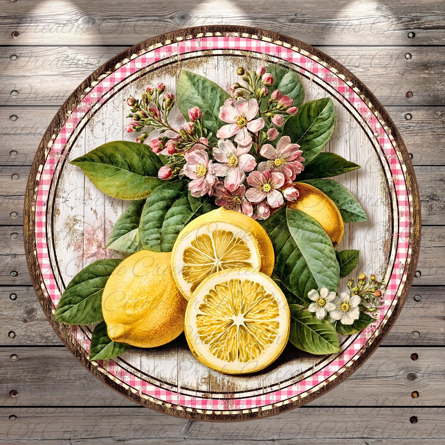 A round wooden platter with a pink and white checkered border, containing a vibrant arrangement of lemons, flowers, and leaves.